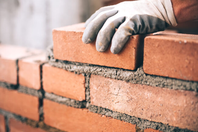 Close up of industrial bricklayer for tradesperson insurance