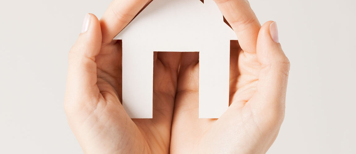 Hands holding a home for property insurance